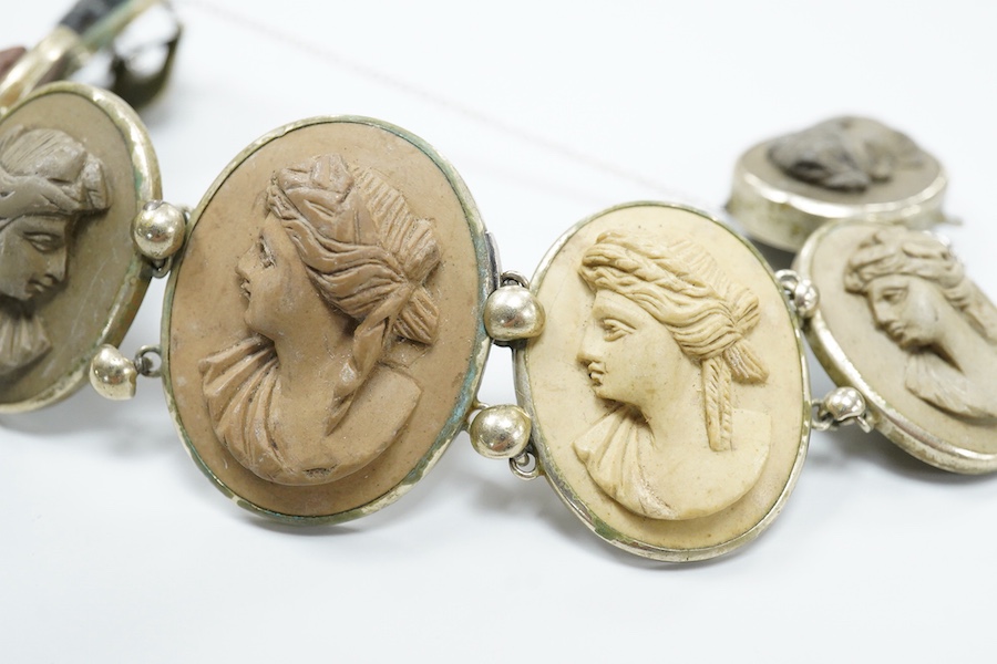 A Victorian base metal bracelet, set with seven graduated lava cameos, carved with the busts of lady's to dexter and sinister, approximately 16.5cm.
